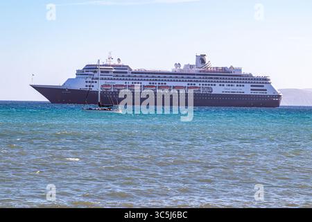 Loreto, basse-Californie du Sud. 11 décembre 2024. Voilier naviguant aux côtés d'un bateau de croisière sur les eaux calmes de la mer de Cortez, ciel bleu brumeux en arrière-plan Banque D'Images