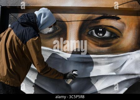 17 mars 2020, Athènes, Grèce : un graffeur grec de 16 ans peint à la bombe un dessin, une femme portant un masque facial faisant référence à la protection contre le coronavirus, sur le toit de son immeuble à Athènes. (Crédit image : © Eurokinissi via ZUMA Wire) Banque D'Images