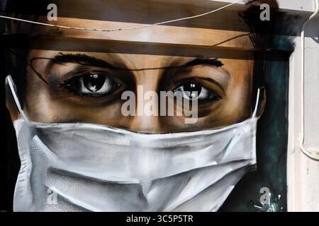 17 mars 2020, Athènes, Grèce : un graffeur grec de 16 ans peint à la bombe un dessin, une femme portant un masque facial faisant référence à la protection contre le coronavirus, sur le toit de son immeuble à Athènes. (Crédit image : © Eurokinissi via ZUMA Wire) Banque D'Images