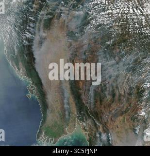 Comme observé au cours des années précédentes en Asie du Sud-est, un grand nombre d’incendies agricoles saisonniers et de feux de forêt créent des nuages de fumée au-dessus du nord de la Thaïlande et de la Birmanie (Myanmar). Le spectroradiomètre imageur à résolution modérée (MODIS) du satellite Aqua de la NASA a acquis cette image en couleurs naturelles le 18 mars 2020. La brume et la fumée ont entraîné des niveaux malsains de pollution de l'air, en particulier à Chiang mai, dans le nord de la Thaïlande, qui a eu l'air le plus pollué au monde plusieurs fois ce mois-ci. Banque D'Images