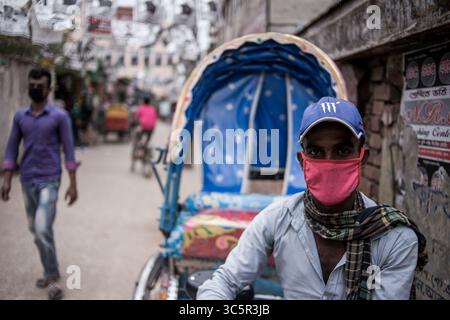 22 mars 2020 : Liton (30) un tire-pousse portant un masque facial.il a dit même s'il a peur de Corona, mais il n'a pas d'autre choix pour sortir tous les jours pour le travail, sinon lui et sa famille vont mourir de faim.au moins 4 personnes sont mortes jusqu'au 22 mars.Chittagong, Bangladesh.22 mars, 2020. (Crédit image : © Jashim Salam/ZUMA Wire) Banque D'Images