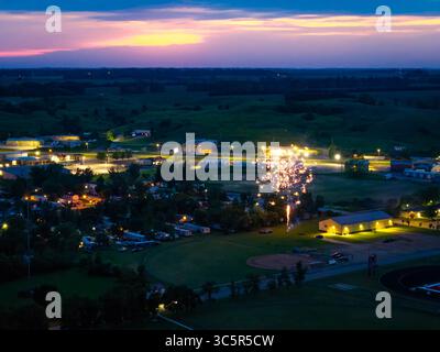Une vue captivante de drone aérien capture une petite communauté célébrant joyeusement avec un feu d'artifice vibrant Banque D'Images