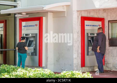 Miami Beach Floride, South Beach, Washington Avenue, deux guichets automatiques de succursale Bank of America installés dans le mur extérieur en marbre sous surplomb blanc avec rouge fr Banque D'Images