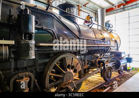 Une image détaillée en gros plan capture un vieux train de locomotives à l'intérieur d'un hangar Banque D'Images