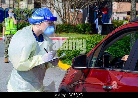 20 mars 2020 - Portsmouth, Virginie, États-Unis - le Lt. j.g. Katherine Baile, une infirmière d'urgence, surveille un patient dans sa voiture au Naval Medical Center Portsmouthâ€™s (NMCP) site de dépistage et de triage de la COVID-19 à l'extérieur du service d'urgence du NMCP, 20 mars 2020. Le PNLP a mis en place un nouveau site de dépistage et de triage au drive-in conçu pour soulager le flux de patients à travers le service des urgences et aider à atténuer la propagation de la COVID-19 en plein air. (Crédit image : © U.S. Navy/ZUMA Wire/ZUMAPRESS.com) Banque D'Images