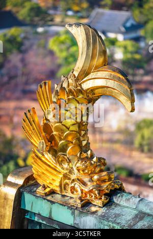 japon, osaka - 6 décembre 2024 : une statue de monstre marin shachihoko doré japonais avec la tête d'un dragon et le corps d'une carpe orne le toit d'Osaka C. Banque D'Images
