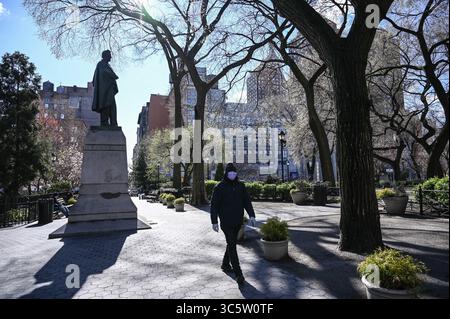 24 mars 2020 - New York, New York, États-Unis - Parc presque vide pendant la pandémie de coronavirus à New York. Hommes avec masque marchant lentement, lumière vive, chaud, Statue de l'ancien président Abraham Lincoln dans Union Square Park Manhattan (crédit image : © Kat Gawin/ZUMA Wire/ZUMAPRESS.com) Banque D'Images