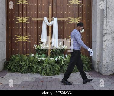 12 avril 2020, Miami, FL, États-Unis : un homme non identifié passe les portes fermées de la cathédrale de Marie alors que les lieux de culte fermaient leurs portes, mais télédiffusent leurs services du dimanche de Pâques via les médias sociaux, car les grands rassemblements sociaux et religieux sont interdits en raison de mandats d'hébergement en place par les gouvernements locaux et étatiques le dimanche de Pâques, 12 avril 2020 à Miami, Floride (crédit image : © TNS via ZUMA Wire) Banque D'Images