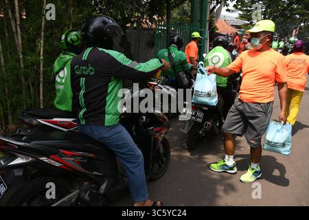 5 septembre 2019, Cipayung, Jakarta, Indonésie : des volontaires donnent des colis alimentaires aux chauffeurs de moto-taxi en ligne dans la région de Cipayung, Jakarta, le 18 avril 2020. Pas moins de 200 colis alimentaires ont été distribués en ligne aux chauffeurs de motos-taxis, car depuis que la co-pandémie a eu lieu en Indonésie, leurs revenus ont diminué. Depuis les nombreuses commandes précédentes pour le transport, les utilisateurs utilisent maintenant des chauffeurs pour commander de la nourriture, magasiner pour les nécessités quotidiennes ou livrer des marchandises. (Crédit image : © Dasril Roszandi/ZUMA Wire) Banque D'Images