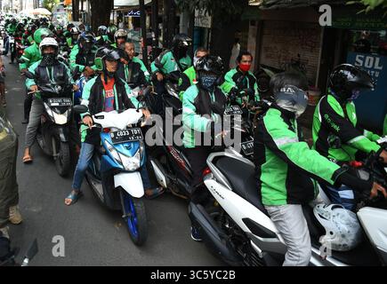 5 septembre 2019, Cipayung, Jakarta, Indonésie : les chauffeurs de moto-taxi en ligne sont prêts à faire la queue pour obtenir des provisions de bénévoles dans la région de Cipayung, Jakarta, le 18 avril 2020. Pas moins de 200 colis alimentaires ont été distribués en ligne aux chauffeurs de motos-taxis, car depuis que la co-pandémie a eu lieu en Indonésie, leurs revenus ont diminué. Depuis les nombreuses commandes précédentes pour le transport, les utilisateurs utilisent maintenant des chauffeurs pour commander de la nourriture, magasiner pour les nécessités quotidiennes ou livrer des marchandises. (Crédit image : © Dasril Roszandi/ZUMA Wire) Banque D'Images