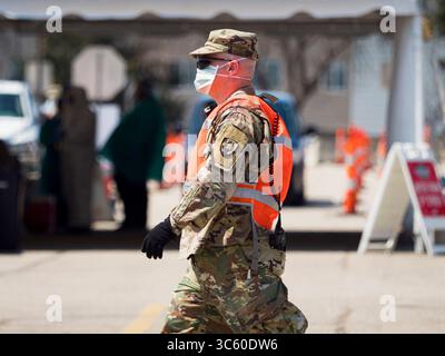 25 avril 2020, des Moines, Iowa, États-Unis : un soldat de la Garde nationale de l’armée de l’Iowa passe devant le site de test de la route COVID-19 à des Moines. L'Iowa a commencé les tests de masse samedi, avec un site d'essai en voiture dans un parking au centre-ville de des Moines. Les tests de ce week-end sont considérés comme une « préouverture » du programme et les tests étaient réservés aux professionnels de la santé et aux premiers intervenants. Malgré de nombreuses épidémies dans les usines d'emballage de viande dans tout l'Iowa, les membres du public n'ont pas pu se faire tester. Le samedi 25 avril, il y avait 5 092 cas confirmés de COVID-19 (Co Banque D'Images