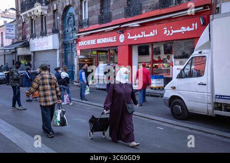 25 avril 2020, Paris, France : une femme musulmane portant un masque facial par précaution, tirant un panier pendant le Ramadan au milieu de la pandémie de coronavirus. À Saint Denis, une banlieue parisienne où la population est majoritairement musulmane, les gens font la queue aux marchés et aux boucheries pour préparer les repas du Ramadan en période de pandémie. Ils portent des masques pour se protéger du virus, mais la distanciation sociale est loin d’être accomplie. (Crédit image : © Andreina Flores/SOPA images via ZUMA Wire) Banque D'Images