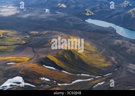 Vue aérienne du terrain volcanique avec rivière, lac et neige en Islande Banque D'Images