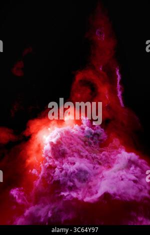 Nébuleuse rouge et violette incandescente avec des nuages de gaz tourbillonnants dans l'espace profond. Banque D'Images