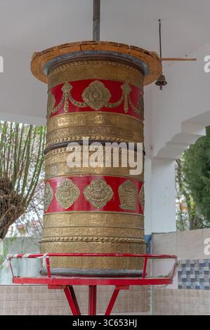 Roue à prières bouddhiste traditionnelle à l'extérieur d'un monastère, symbole de foi et de spiritualité, utilisée pour la méditation et le chant de mantras. Banque D'Images