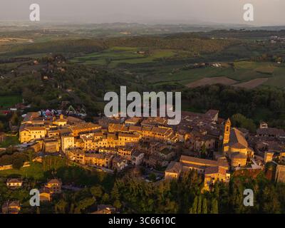 Vue aérienne de la ville rustique de Montepulciano se prélasser dans la lueur chaude du coucher du soleil, avec ses toits en terre cuite et ses anciennes structures en pierre contrastant Banque D'Images