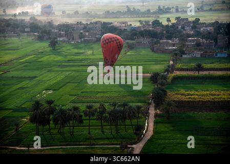 La montgolfière atterrit dans un champ verdoyant près de Louxor, en Égypte, lors d'un vol en montgolfière tôt le matin Banque D'Images