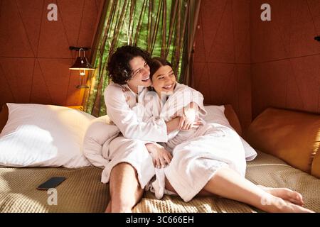 Un couple aimant partage un moment chaleureux dans leur retraite de vacances confortable, embrassant joyeusement. Banque D'Images