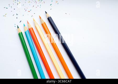 Une rangée soignée de différents crayons de couleur est alignée sur une surface blanche Banque D'Images
