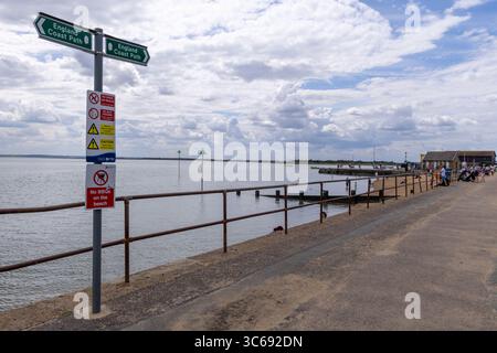 Sentier côtier à Leigh-on-Sea, Essex, Angleterre, avec panneau indiquant le chemin côtier de l'Angleterre. Avertissements de sécurité et passerelle panoramique au bord de l'eau. Banque D'Images