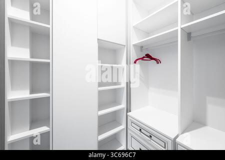 Armoire vide avec trois cintres. Placard d'angle vide avec trois cintres rouges. Banque D'Images