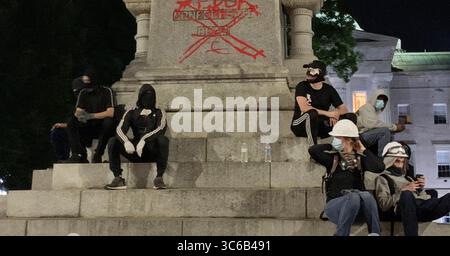 31 mai 2020, Raleigh, Caroline du Nord, États-Unis : un groupe d'hommes assis à la base d'une statue confédérée sur le terrain du Capitole de Raleigh, Caroline du Nord, après que les manifestants ont peint des messages à la bombe, le 31 mai 2020. (Crédit image : © TNS via ZUMA Wire) Banque D'Images