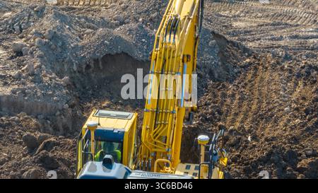 Image aérienne, aérienne, d'une excavatrice travaillant sur un chantier de construction déplaçant la terre, la terre. Terrassement, excavations, creusement sur les sols Banque D'Images