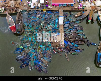 Vue aérienne d'un port animé rempli de bateaux colorés regroupant autour d'une jetée étroite sous le soleil, une scène vibrante de l'activité maritime, Port Harcourt, Rivers State, Nigeria. Banque D'Images