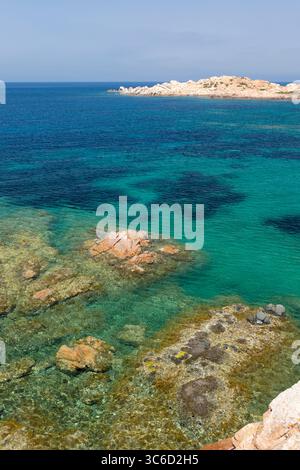 Caprera, Parc National de l'archipel de la Maddalena, Gallura, Sardaigne, Italie. Vue sur l'eau turquoise calme jusqu'au promontoire rocheux de Punta Crucitta. Banque D'Images