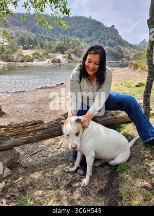 Une femme adulte latina passe du temps à l'extérieur avec son chien de soutien émotionnel comme thérapie pour le stress et l'anxiété Banque D'Images