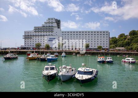 Surplombant les petits bateaux amarrés dans le port de Folkestone jusqu'à la façade blanche de l'hôtel Grand Burstin. Banque D'Images