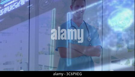 Médecin debout portant des gommages bleus croisant les bras à la fenêtre de la clinique, avec stéthoscope, superpositions de données Banque D'Images