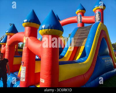 Toronto, ON, Canada – 31 mai 2024 : les familles se rassemblent autour de grands toboggans gonflables et de parcours d’obstacles lors d’un événement pour enfants par un après-midi ensoleillé. Banque D'Images