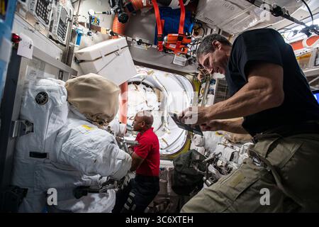 8 janvier 2021 - atmosphère terrestre - les ingénieurs de vol Michael Hopkins (au premier plan) et Victor Glover configurent des outils à l'intérieur du sas Quest pour les sorties dans l'espace prévues afin de poursuivre la maintenance à l'extérieur de la Station spatiale internationale. (Crédit image : © NASA/ZUMA Wire) Banque D'Images