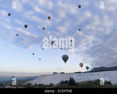 Les montgolfières flottent au-dessus d'un paysage pittoresque sous un ciel nuageux, vue aérienne, Pamukkale, Denizli, Anatolie, Turquie Banque D'Images