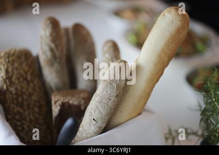 Différents types de pain dans un panier, en arrière-plan une table de buffet floue, Cologne, Rhénanie du Nord-Westphalie, Allemagne Banque D'Images