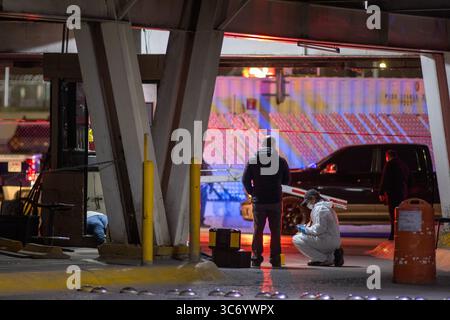 Un enquêteur médico-légal enquête sur la scène de violence urbaine à Ciudad Juarez. Banque D'Images