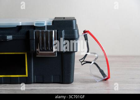 Boîte à outils en métal classique avec loquet fixé sur un établi en bois rustique, prêt pour les projets de bricolage et le stockage d'outils professionnel Banque D'Images