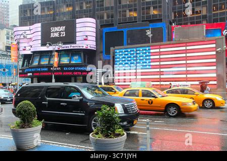 NEW YORK, États-Unis - 10 JUIN 2013 : les taxis jaunes roulent sous la pluie à Times Square, NY. Times Square est l'un des endroits les plus reconnus au monde. Banque D'Images