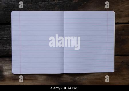 Cahier d'école ouvert doublé sur une table en bois et vue de dessus, pages vierges pour les notes utilisées comme modèle ou arrière-plan Banque D'Images