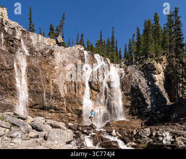 La pose Waterfall Yoga Tree est présentée aux chutes Athabasca dans le parc national Jasper. Les chutes sont un arrêt populaire pour les touristes et les photographes Banque D'Images