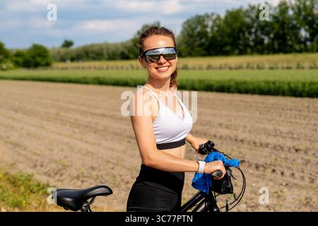 Jeune femme en forme de vélo à l'extérieur dans le paysage rural Banque D'Images