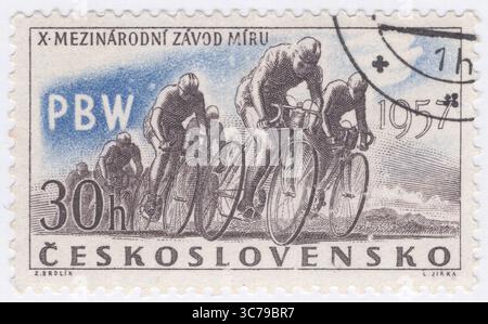 TCHÉCOSLOVAQUIE - 1957 avril 30 : timbre-poste à 30 haleru sépia et outremer représentant des cyclistes en course. 10ème course cycliste internationale de la paix, Prague-Berlin-Varsovie. La course a été initiée par les journaux officiels du parti communiste de Pologne et de Tchécoslovaquie dans le but explicite de promouvoir "la paix et l'amitié" entre les Nations, en particulier au sein du bloc de l'est émergent. Alors que la course était clairement utilisée pour la propagande politique et idéologique - mettant en valeur les « réalisations du socialisme » et contrastant avec le commercialisme des races occidentales - il s'agissait indéniablement d'un sport de haut niveau Banque D'Images