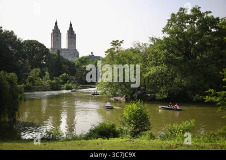 New York, États-Unis. 3 juin 2025. Les gens ramènent les bateaux sur le lac dans Central Park avec le bâtiment emblématique de San Remo en arrière-plan. (Crédit image : © Apolline Guillerot-Malick/SOPA images via ZUMA Press Wire) USAGE ÉDITORIAL SEULEMENT ! Non destiné à UN USAGE commercial ! Banque D'Images