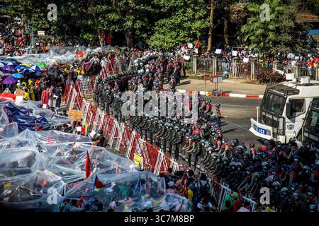 9 février 2021, Yangon, Myanmar : les manifestants se couvrent de papier plastique et de parapluies alors que la police les avertit de se disperser ou de se faire arroser d'eau à Hledan pendant la quatrième journée de manifestations contre le coup d'État militaire. Des milliers de personnes sont descendues dans les rues de Yangon le quatrième jour de manifestation contre le coup d'État militaire et ont exigé la libération d'Aung San Suu Kyi. L'armée du Myanmar a arrêté la conseillère d'État du Myanmar Aung San Suu Kyi le 1er février 2021 et a déclaré l'état d'urgence tout en prenant le pouvoir dans le pays pendant un an après avoir perdu l'élection contre Banque D'Images