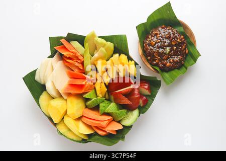 Rujak (Roejak), un plat traditionnel indonésien composé de fruits et légumes frais variés, servi avec une sauce aux cacahuètes sucrée et épicée. Banque D'Images