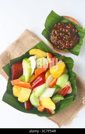 Rujak (Roejak), un plat traditionnel indonésien composé de fruits et légumes frais variés, servi avec une sauce aux cacahuètes sucrée et épicée. Portrait. Banque D'Images