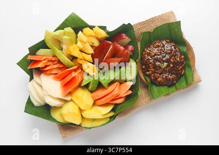 Vue de dessus du Rujak (Roejak), un plat traditionnel indonésien composé de fruits et légumes frais variés, servi avec une sauce aux cacahuètes sucrée et épicée. Banque D'Images
