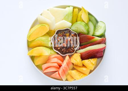 Vue de dessus du Rujak (Roejak), un plat traditionnel indonésien avec fruits et légumes frais assortis, disposés sur une assiette blanche. Banque D'Images