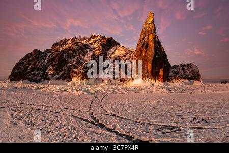 Une vue imprenable sur les montagnes enneigées du lac baïkal, en Russie, illuminée par la douce lueur du lever du soleil. La vaste étendue de terrain glacé crée Banque D'Images